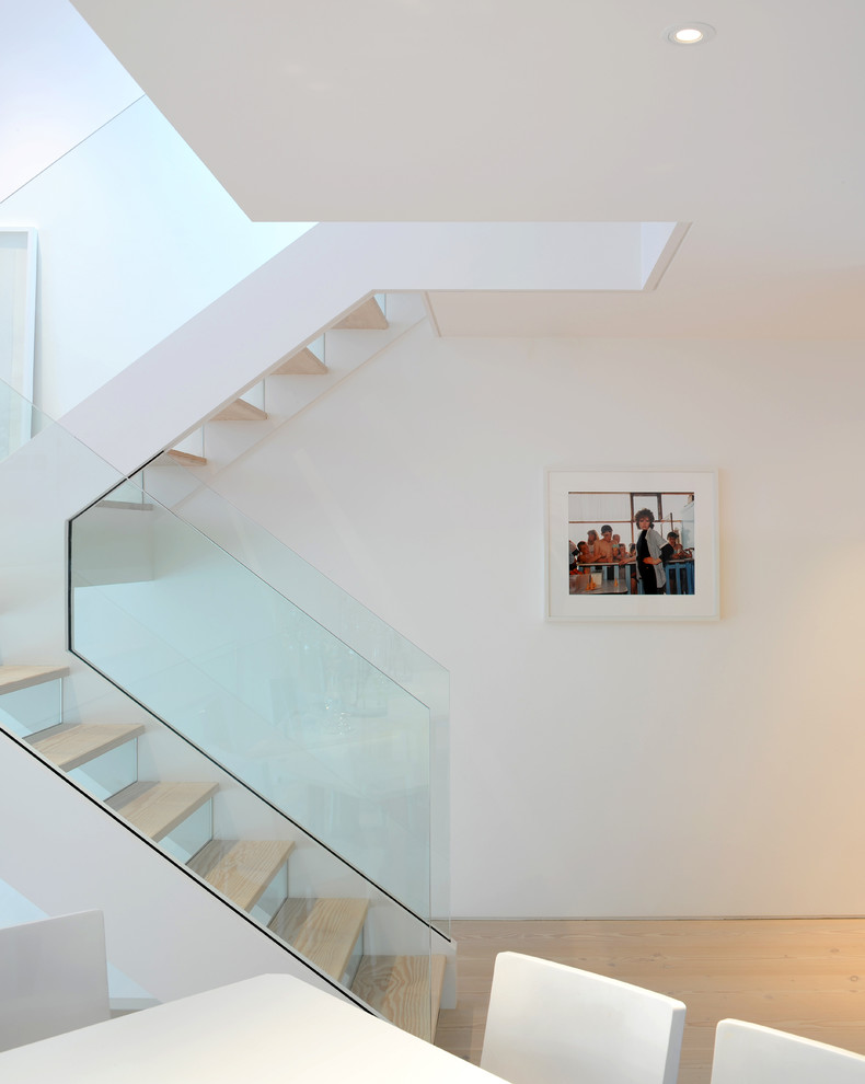 Exemple d'un escalier scandinave en U avec des marches en bois, des contremarches en verre et palier.