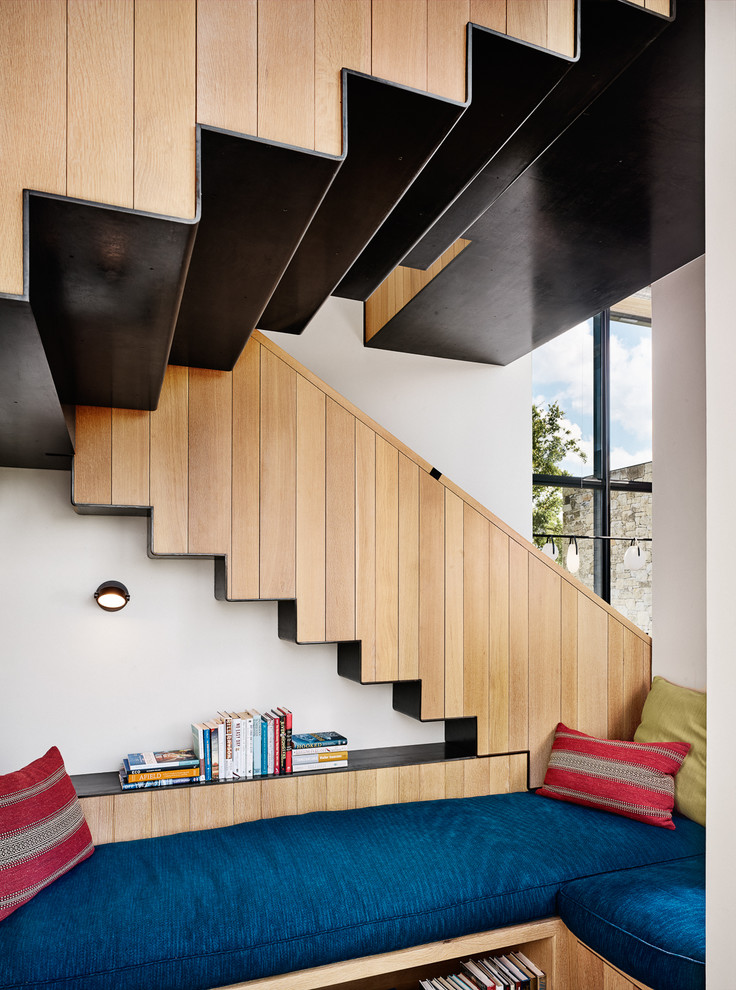 На фото: большая п-образная металлическая лестница в стиле модернизм с деревянными ступенями и металлическими перилами