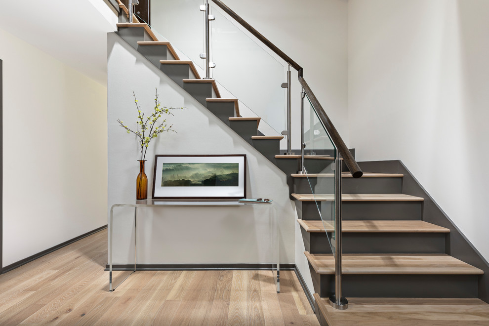 Стильный дизайн: большая изогнутая лестница в стиле модернизм с деревянными ступенями, крашенными деревянными подступенками и перилами из смешанных материалов - последний тренд