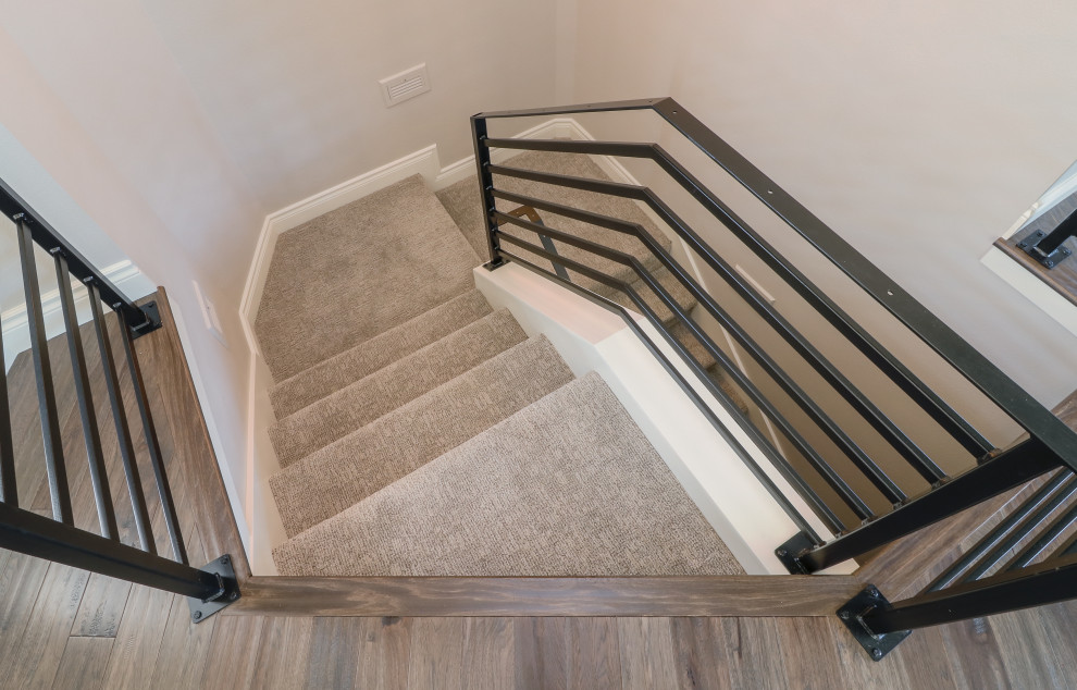 Стильный дизайн: большая п-образная лестница в классическом стиле с ступенями с ковровым покрытием, ковровыми подступенками и металлическими перилами - последний тренд
