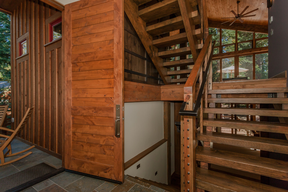 На фото: большая п-образная деревянная лестница в стиле кантри с деревянными ступенями и перилами из смешанных материалов с