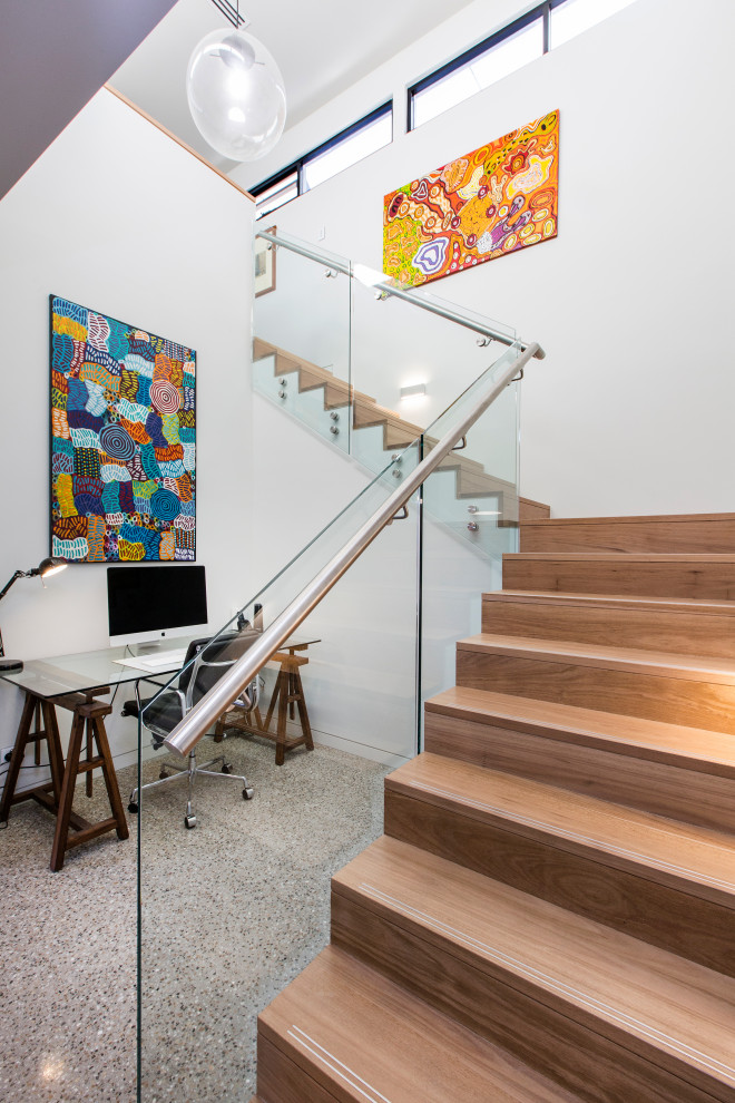 На фото: большая угловая деревянная лестница в современном стиле с деревянными ступенями и стеклянными перилами с
