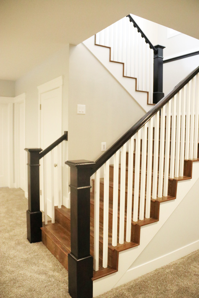 This is an example of a medium sized classic wood u-shaped wood railing staircase in Salt Lake City with wood risers.