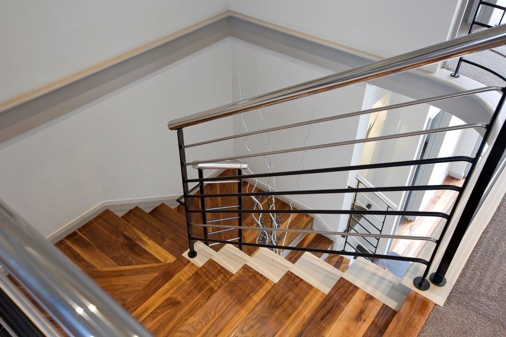 Идея дизайна: угловая лестница среднего размера в стиле модернизм с ступенями из плитки, подступенками из плитки, металлическими перилами и панелями на стенах