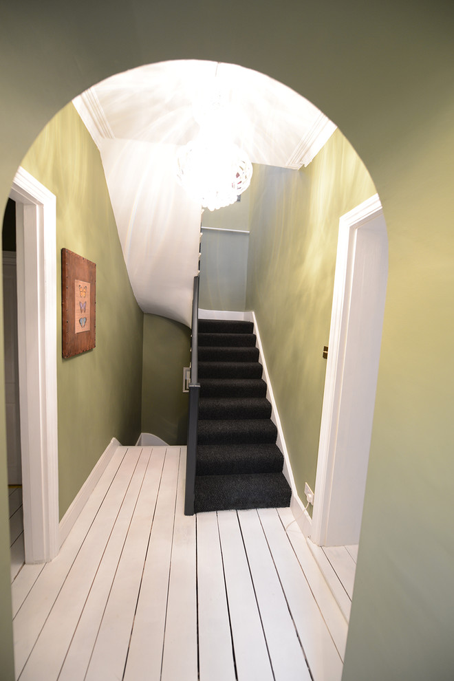 Photo of a large classic carpeted u-shaped staircase in London with carpeted risers.