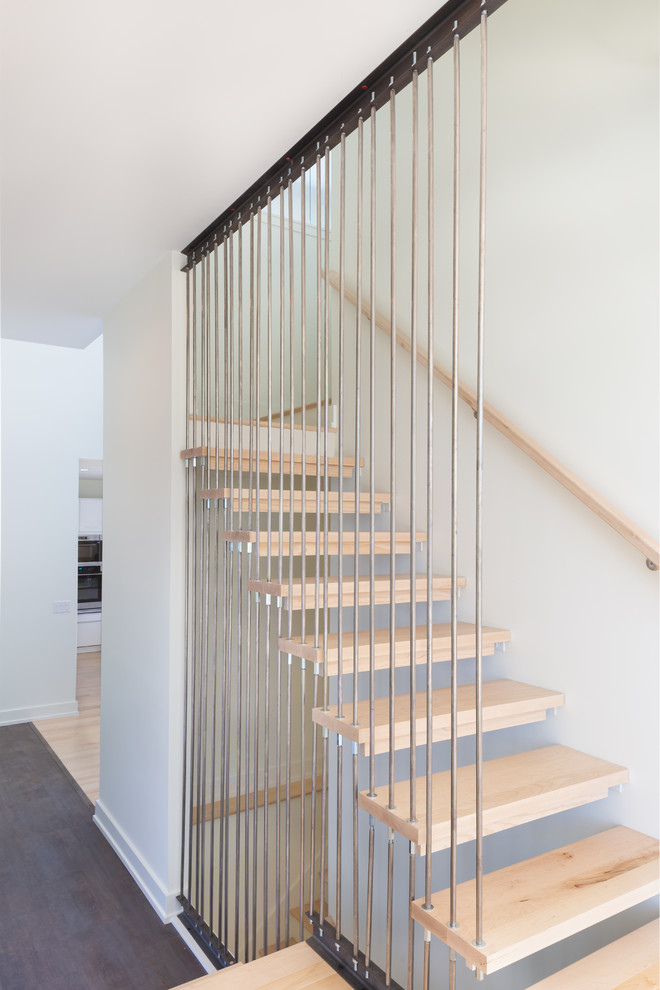 Inspiration pour un escalier sans contremarche flottant minimaliste de taille moyenne avec des marches en bois et un garde-corps en câble.
