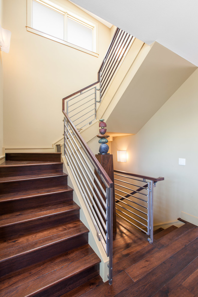 This is an example of a large contemporary wood curved staircase in Denver with wood risers.