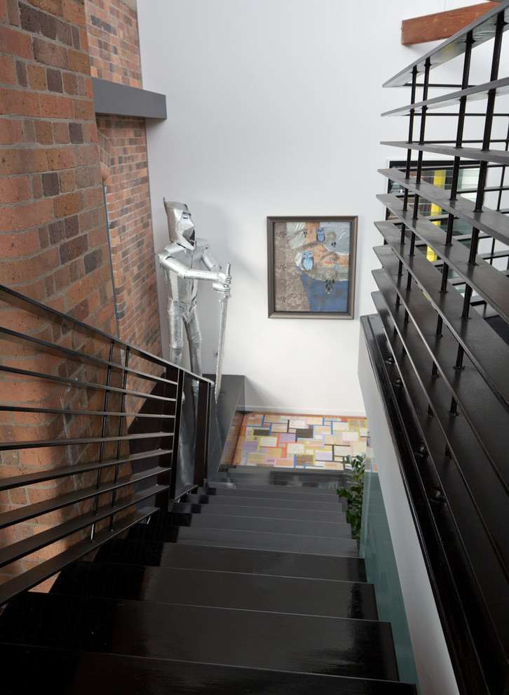 Idée de décoration pour un escalier droit urbain de taille moyenne avec un garde-corps en métal.