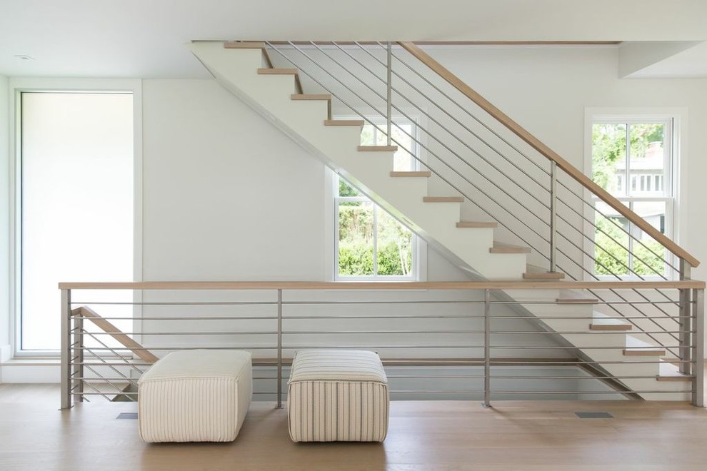 Cette image montre un escalier droit design avec des marches en bois et un garde-corps en matériaux mixtes.