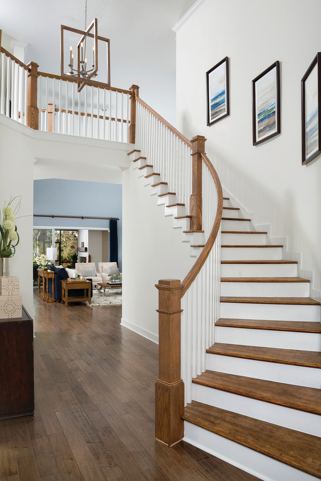 Diseño de escalera curva tradicional renovada con escalones de madera, contrahuellas de madera y barandilla de madera