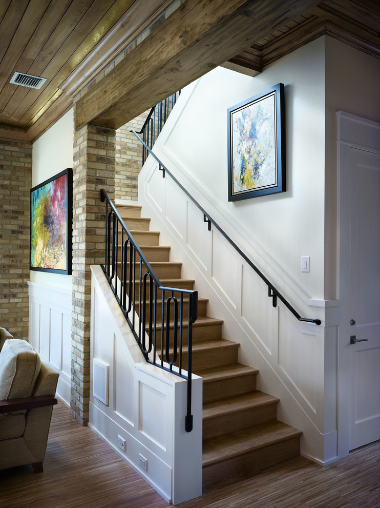Ejemplo de escalera en U actual con escalones de madera, contrahuellas de madera y barandilla de metal