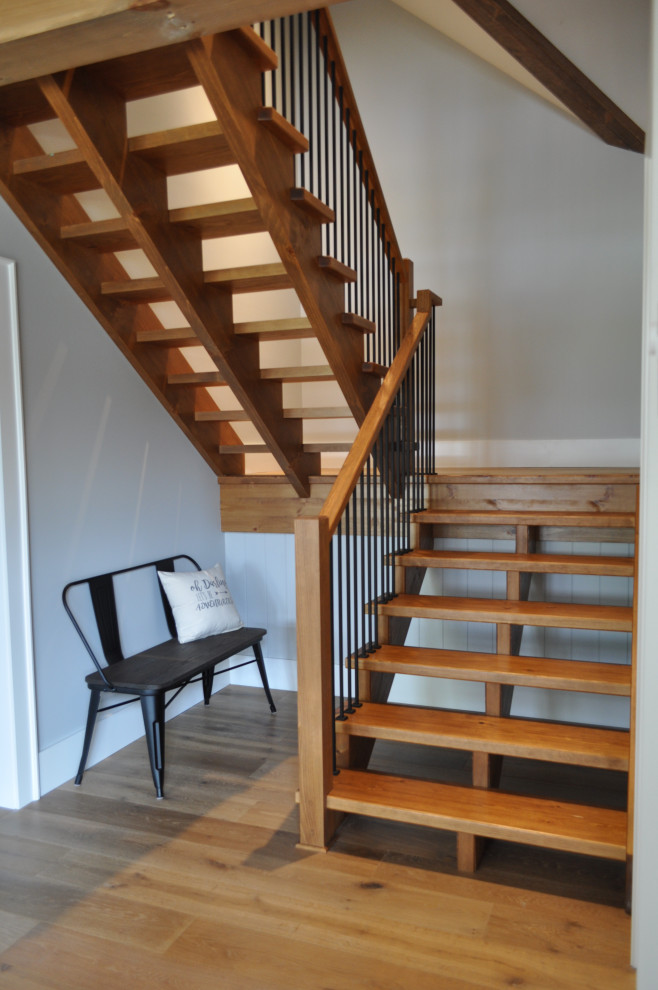 Пример оригинального дизайна: большая деревянная лестница на больцах в стиле кантри с деревянными ступенями, деревянными перилами и деревянными стенами
