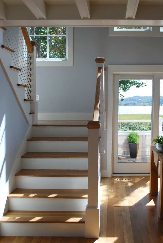 Diseño de escalera en L costera de tamaño medio con escalones de madera, contrahuellas de madera y barandilla de cable