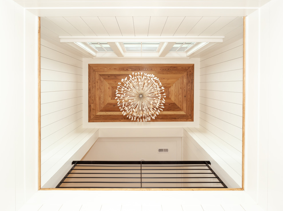Esempio di una grande scala a "U" stile marinaro con pedata in legno, alzata in legno verniciato, parapetto in metallo e pareti in perlinato