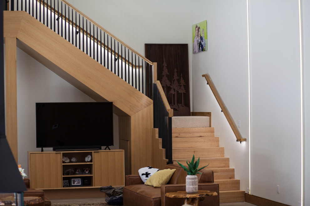 На фото: угловая деревянная лестница среднего размера в стиле модернизм с деревянными ступенями и деревянными перилами с