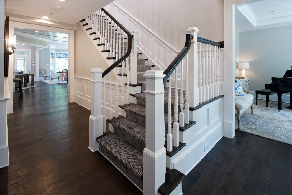 Пример оригинального дизайна: угловая лестница среднего размера в классическом стиле с ступенями с ковровым покрытием, деревянными перилами, панелями на стенах и ковровыми подступенками