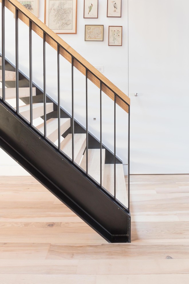 Design ideas for a medium sized contemporary wood straight metal railing staircase in Hertfordshire with open risers.