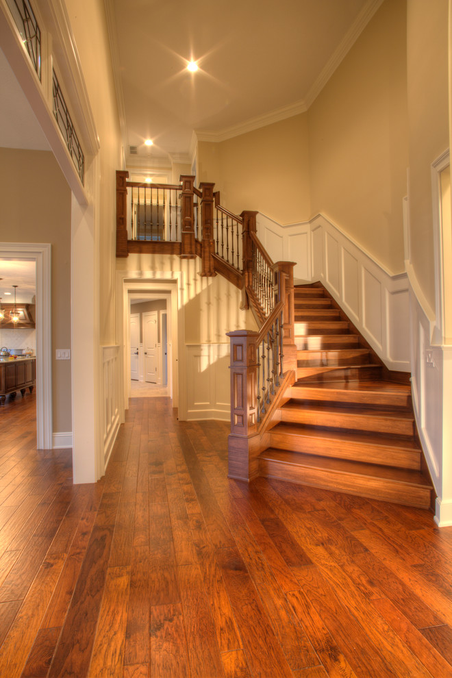 Example of a huge mid-century modern wooden curved staircase design in Cleveland with wooden risers