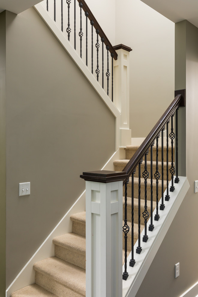 Photo of a medium sized classic carpeted l-shaped wood railing staircase in Grand Rapids with carpeted risers.