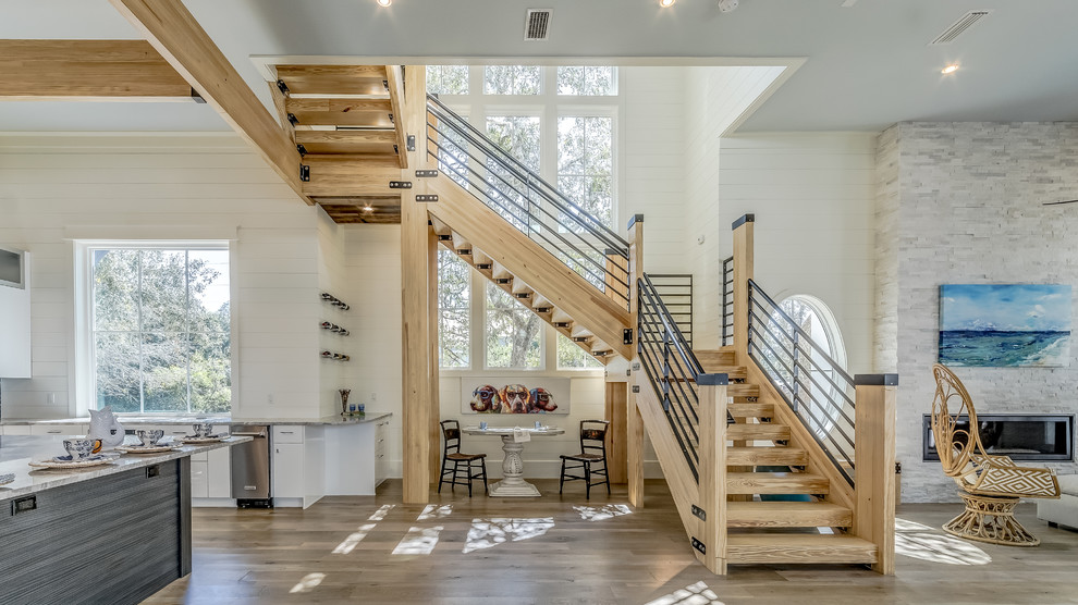 Свежая идея для дизайна: большая п-образная лестница в морском стиле с деревянными ступенями и металлическими перилами без подступенок - отличное фото интерьера