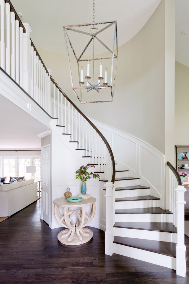 Стильный дизайн: изогнутая лестница в стиле неоклассика (современная классика) с деревянными ступенями и деревянными перилами - последний тренд