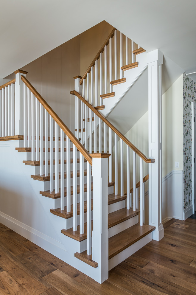На фото: п-образная лестница среднего размера в морском стиле с деревянными ступенями и крашенными деревянными подступенками