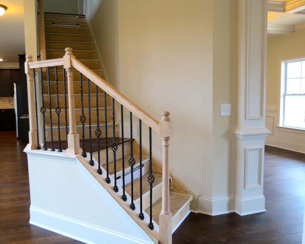 Cette image montre un grand escalier craftsman en L avec des marches en bois et des contremarches en bois.