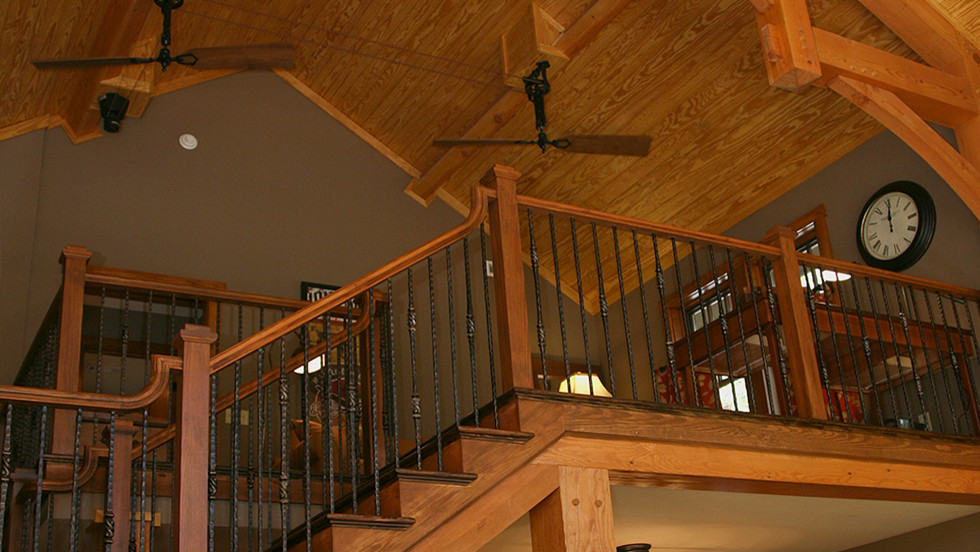 На фото: большая угловая деревянная лестница в стиле кантри с деревянными ступенями с
