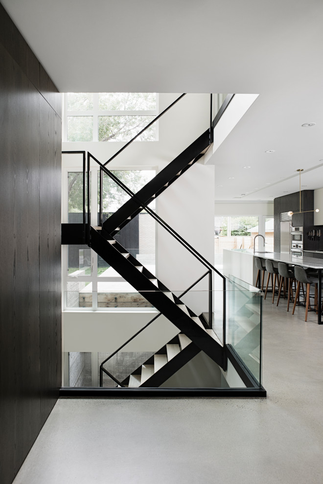 Cette photo montre un escalier flottant tendance de taille moyenne avec des marches en métal, des contremarches en bois et un garde-corps en métal.