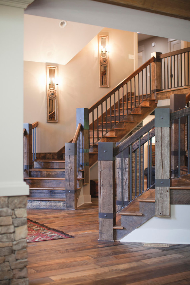 Cette image montre un grand escalier courbe chalet avec des marches en bois, des contremarches en bois et un garde-corps en bois.