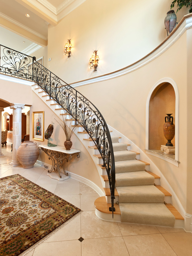 Источник вдохновения для домашнего уюта: изогнутая лестница в средиземноморском стиле с деревянными ступенями и крашенными деревянными подступенками