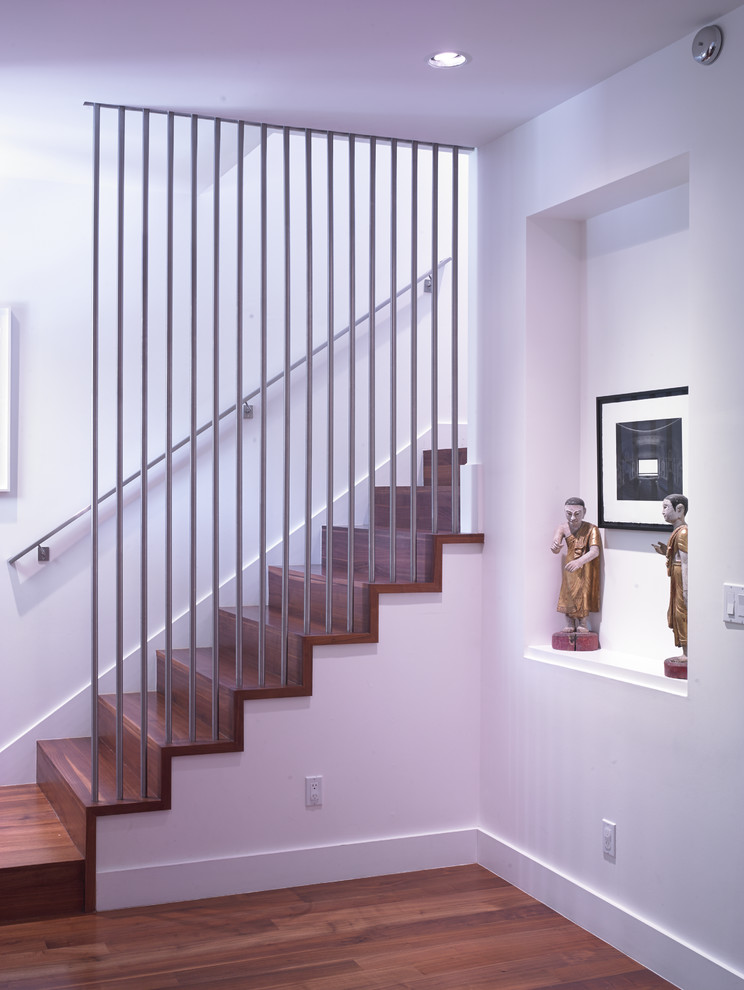 Immagine di una scala a rampa dritta minimalista di medie dimensioni con pedata in legno e alzata in legno