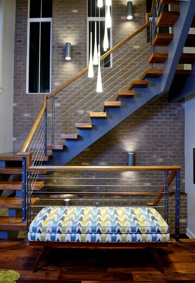 Идея дизайна: огромная лестница на больцах в современном стиле с деревянными ступенями и перилами из тросов без подступенок
