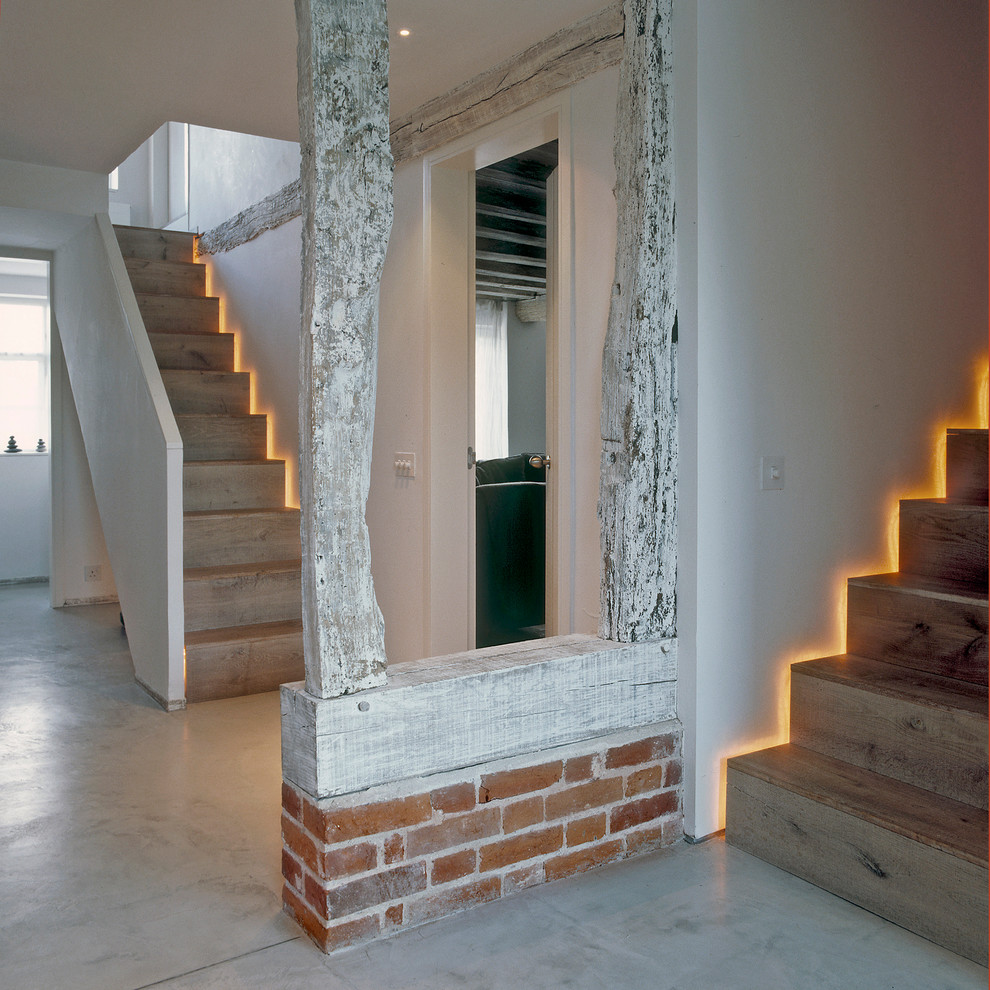 Inspiration for a mid-sized contemporary wooden straight staircase remodel in London with wooden risers