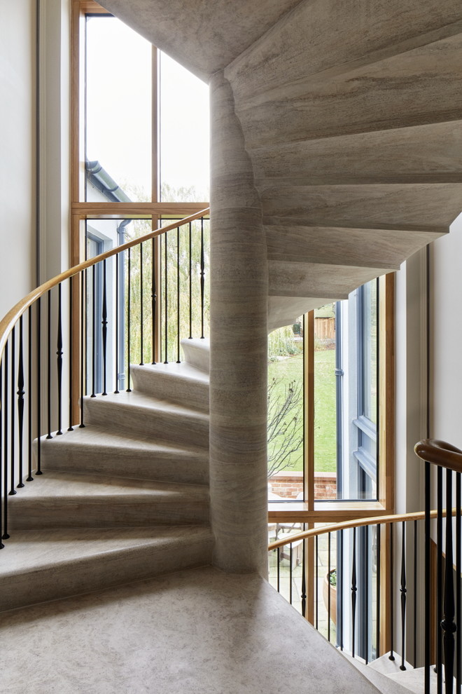Cette image montre un escalier hélicoïdal traditionnel en béton avec des contremarches en béton et un garde-corps en matériaux mixtes.