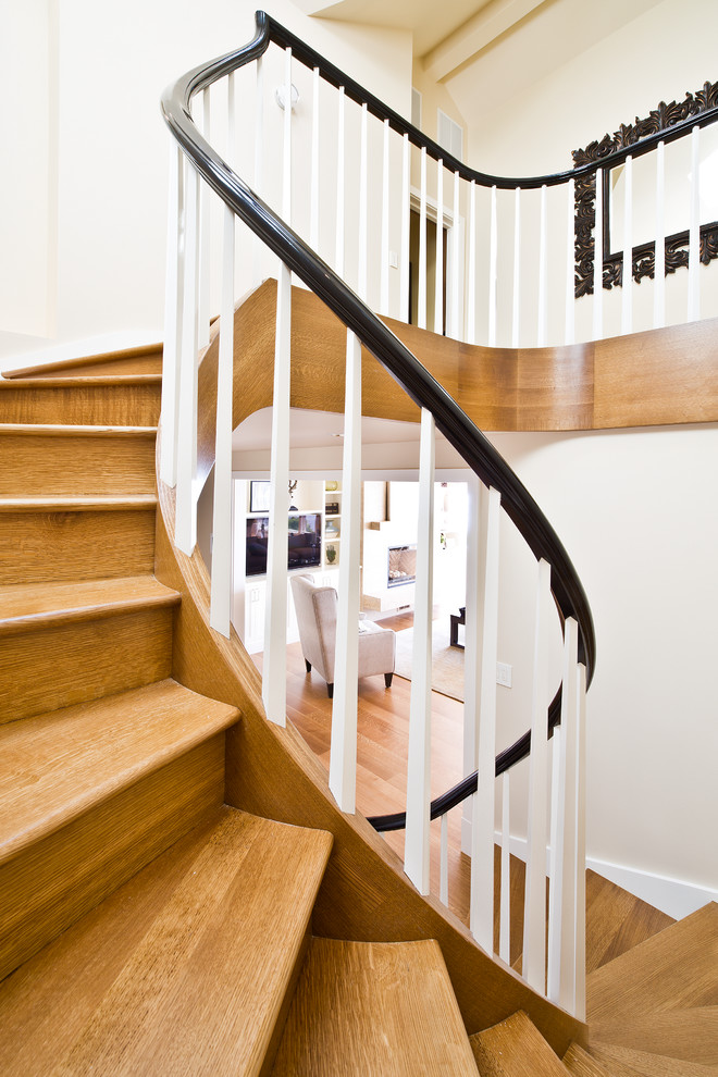 Réalisation d'un grand escalier courbe tradition avec des marches en bois et des contremarches en bois.