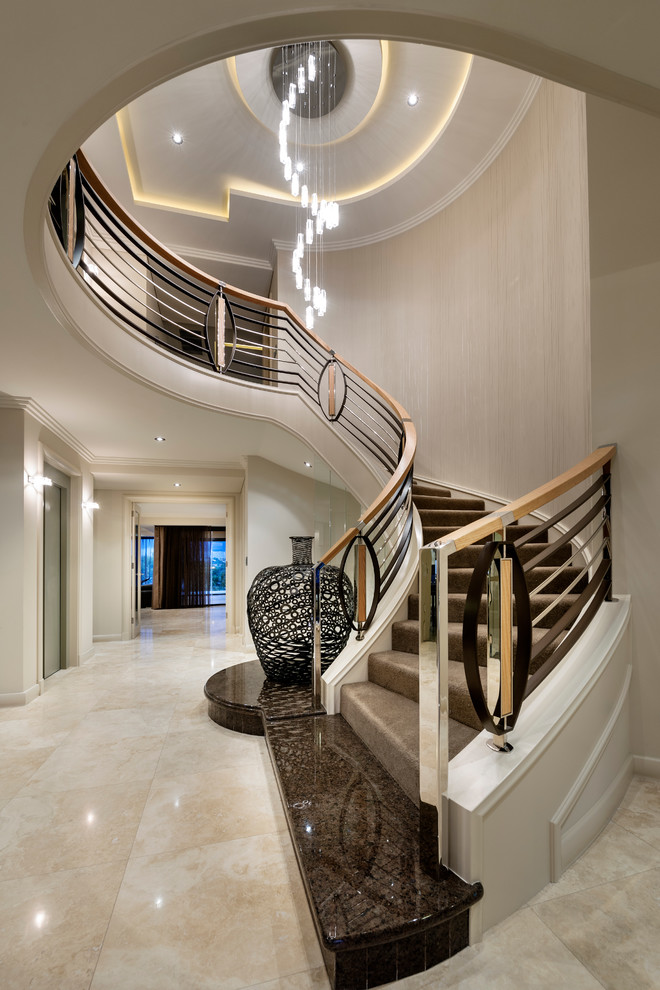На фото: большая изогнутая лестница в современном стиле с ступенями с ковровым покрытием и ковровыми подступенками с