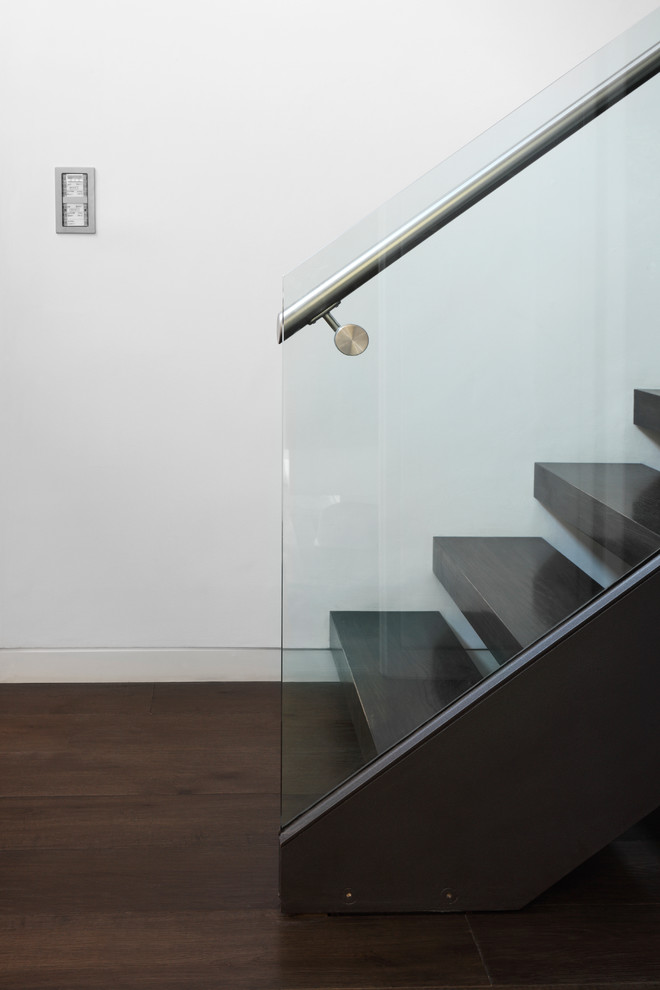 Medium sized contemporary wood u-shaped staircase in London with open risers.