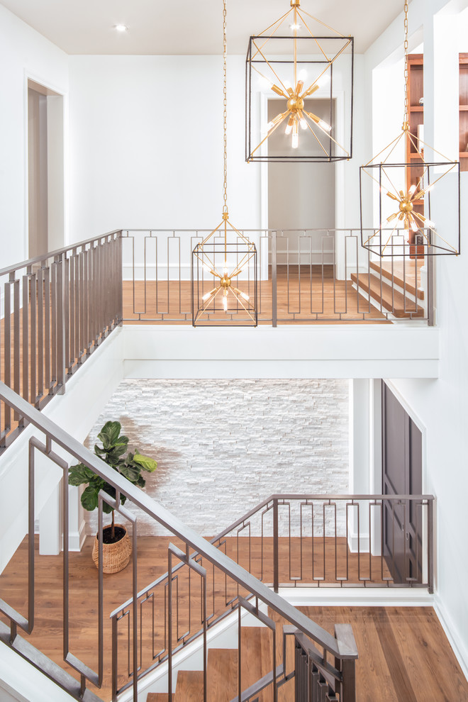 Imagen de escalera en U tradicional renovada con escalones de madera, contrahuellas de madera pintada y barandilla de metal