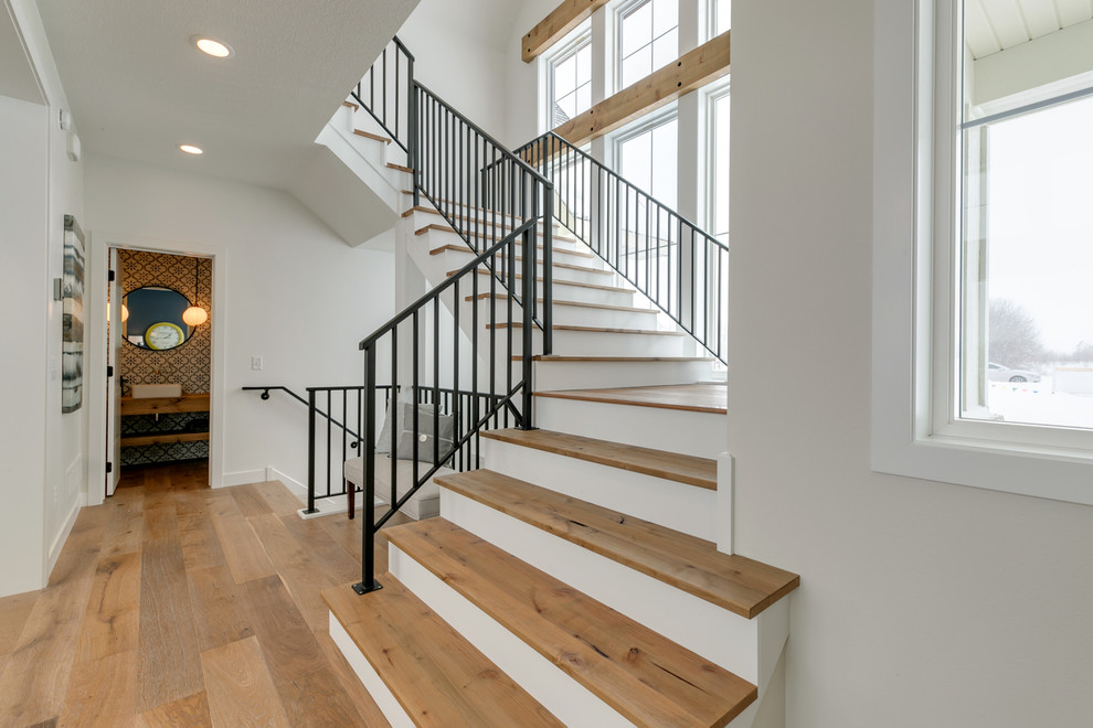Ejemplo de escalera suspendida de estilo de casa de campo de tamaño medio con escalones de madera, contrahuellas de madera pintada y barandilla de metal