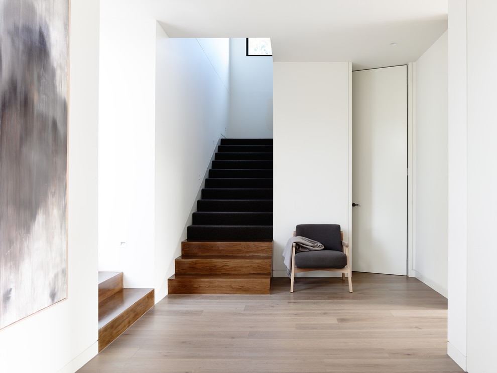 Ejemplo de escalera en U moderna con escalones de madera y contrahuellas de madera