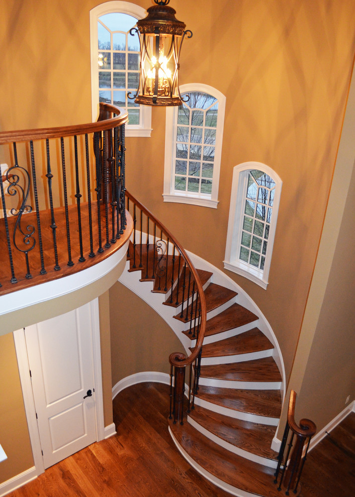 Cette image montre un grand escalier peint hélicoïdal craftsman avec des marches en bois.