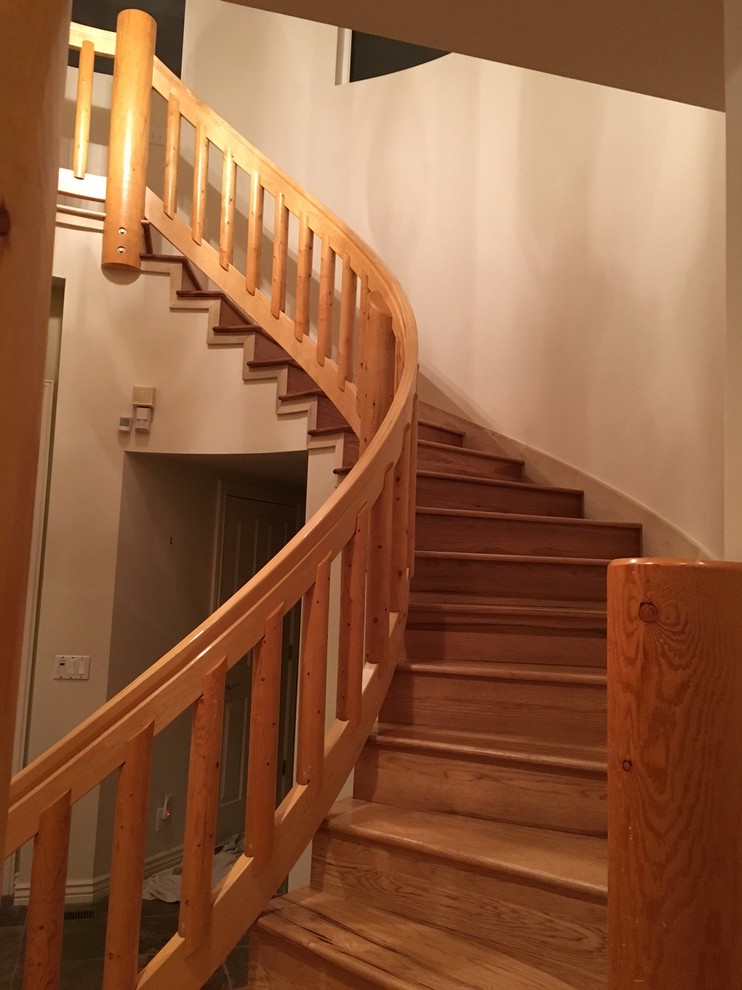 Photo of a large rustic wood curved staircase in Salt Lake City with wood risers.