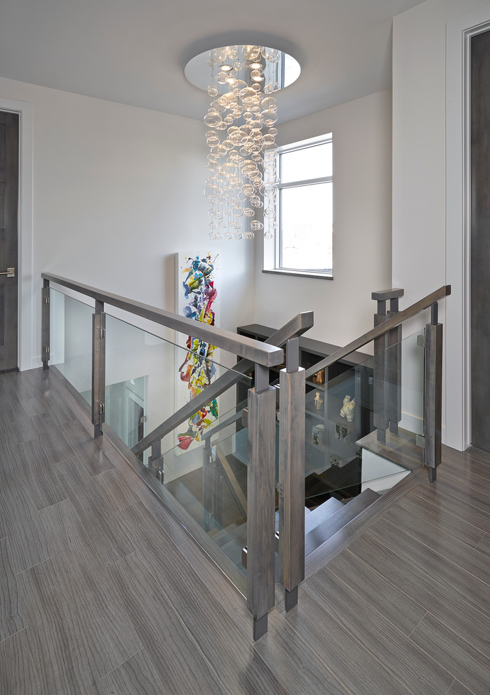Пример оригинального дизайна: лестница в современном стиле с стеклянными перилами