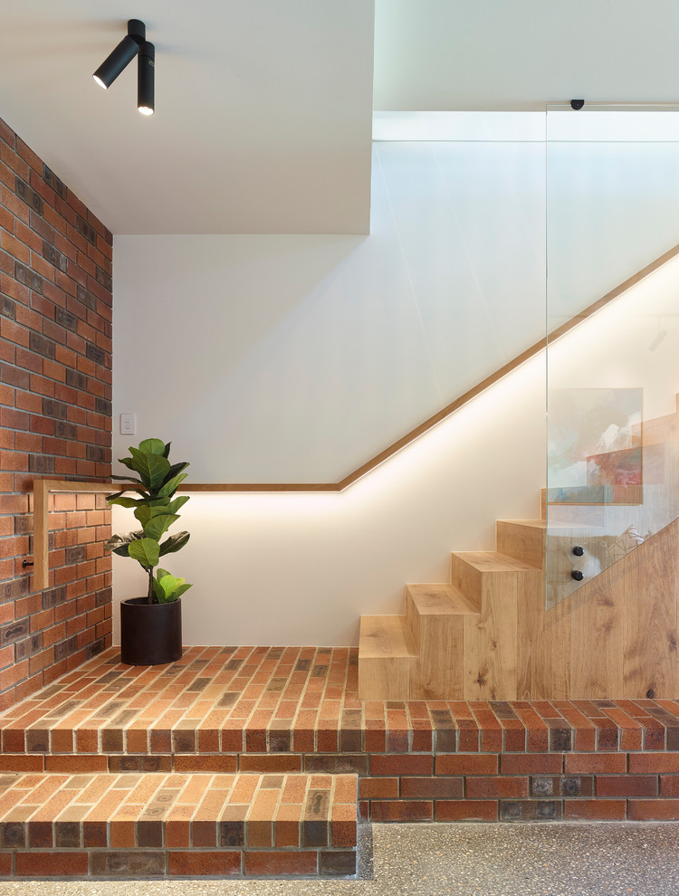 Modelo de escalera recta contemporánea con escalones de madera, contrahuellas de madera y barandilla de vidrio