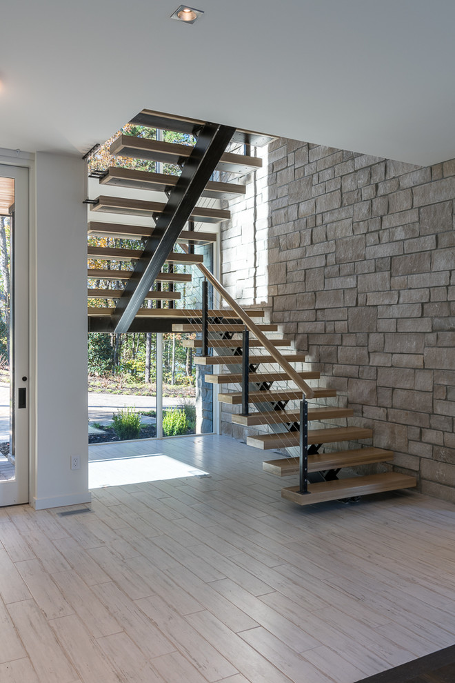 На фото: п-образная лестница среднего размера в стиле модернизм с деревянными ступенями и перилами из смешанных материалов без подступенок
