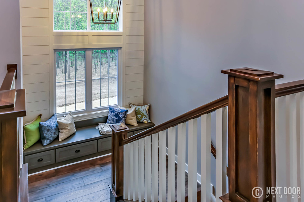 Photo of a large rural wood u-shaped wood railing staircase in Grand Rapids with wood risers.