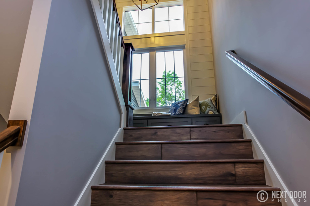 Large farmhouse wooden u-shaped wood railing staircase photo in Grand Rapids with wooden risers
