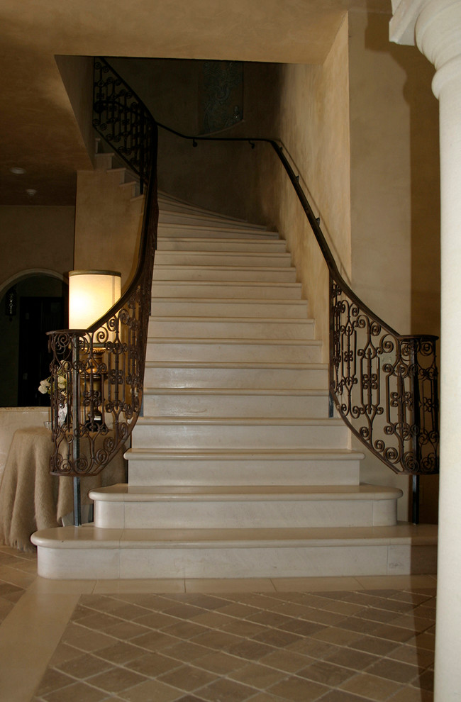 На фото: изогнутая металлическая лестница среднего размера в средиземноморском стиле с бетонными ступенями с