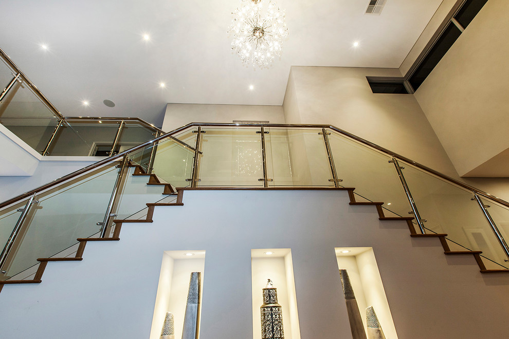 Idée de décoration pour un très grand escalier droit design avec des marches en bois et des contremarches en bois.